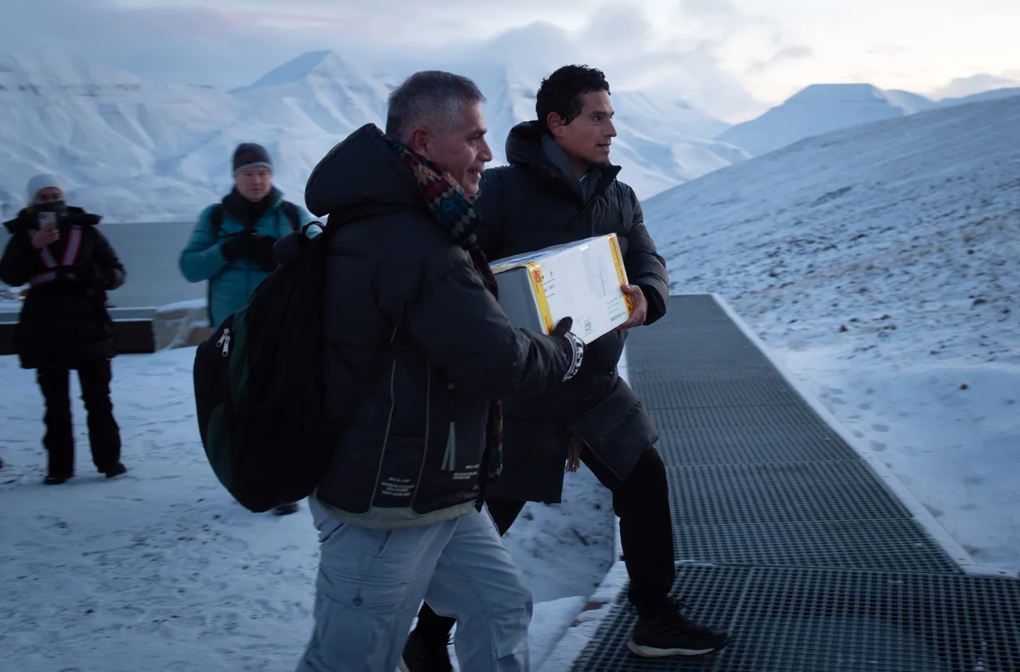 Two men carries a box