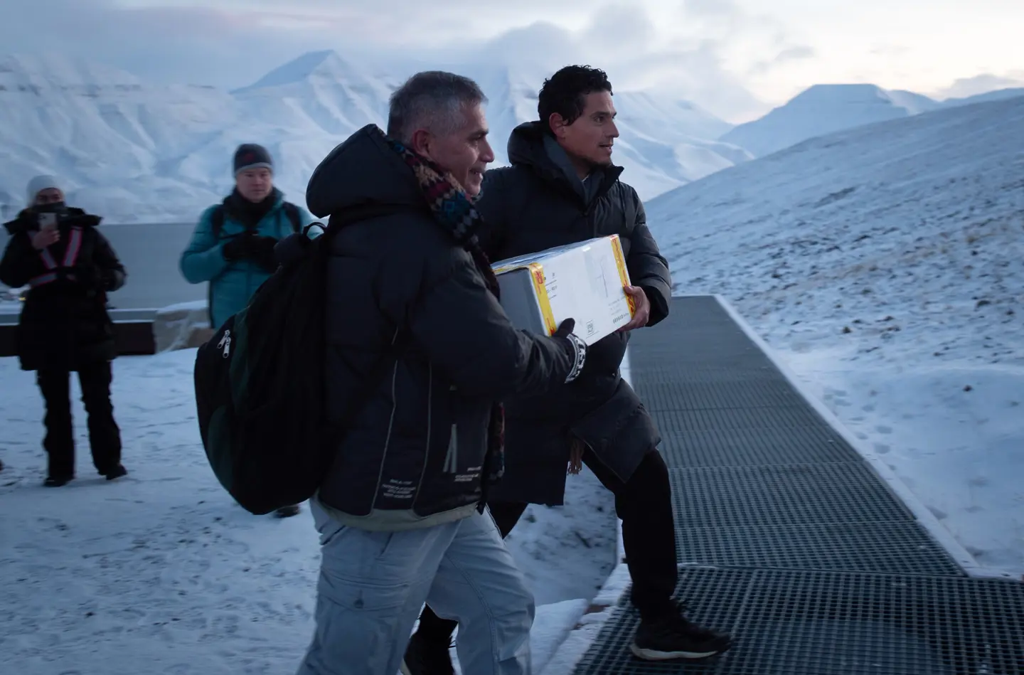 Two men carries a box